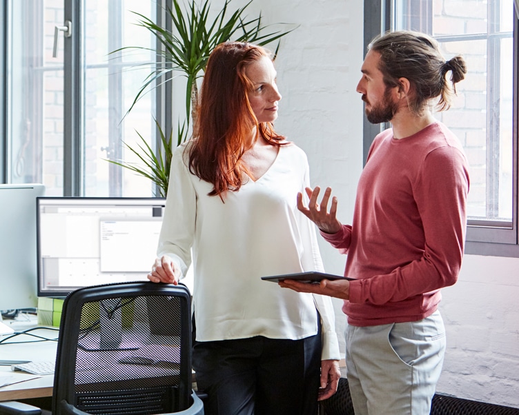 A woman and a man talking in an office